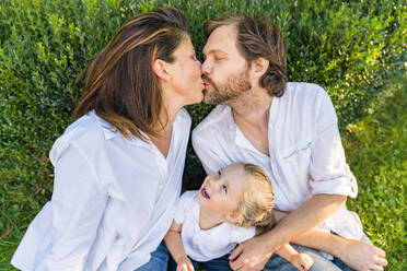 Eltern küssen ihre kleine Tochter und schauen zu - MGIF00776