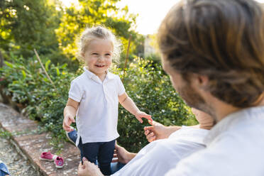 Porträt eines glücklichen kleinen Mädchens mit Eltern in einem Park - MGIF00782