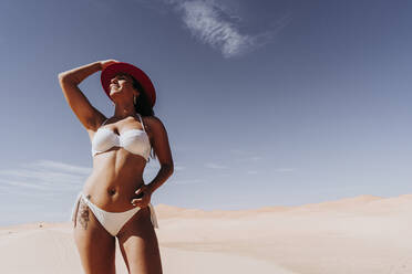 Beautiful young woman wearing bikini in the desert, Merzouga, Morocco - DAMF00129