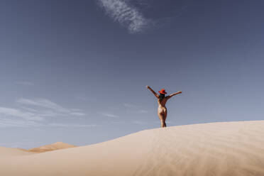 Nude young woman wearing a hat in the desert, Merzouga, Morocco - DAMF00130