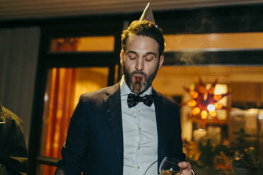 Man smoking cigar at party - JOHF02174