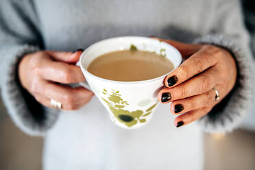 Eine Frau hält eine Tasse Kaffee in der Hand - JOHF02188