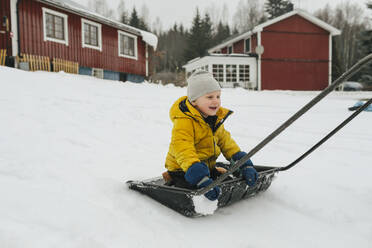 Junge auf Schlitten Schneeschaufel - JOHF02236