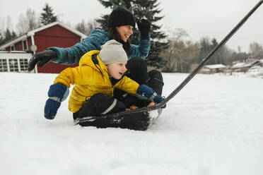 Mutter mit Sohn auf Schlitten Schneeschaufel - JOHF02238