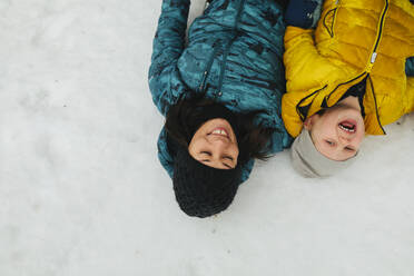 Mutter mit Sohn im Schnee liegend - JOHF02239