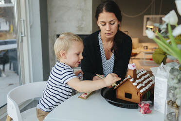 Mother with son decorating gingerbread house - JOHF02259