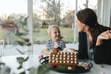 Mother with son decorating gingerbread house - JOHF02262