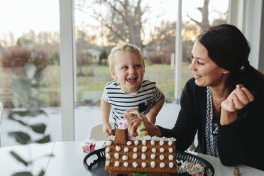 Mother with son decorating gingerbread house - JOHF02263