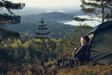 Man sitting in front of tent - JOHF02404