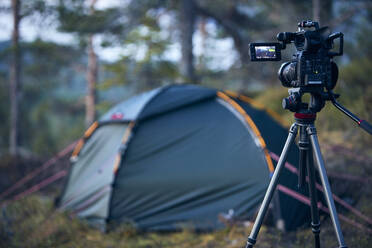 Camera on tripod, tent on background - JOHF02408