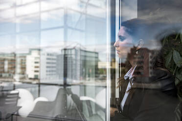 Woman looking through window - JOHF02418