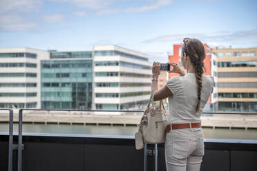 Frau auf Balkon beim Fotografieren - JOHF02437