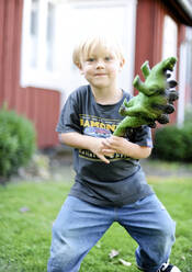 Junge spielt mit Dinosaurier Spielzeug - JOHF02485