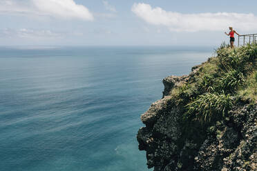 Woman on top of cliff - JOHF02574