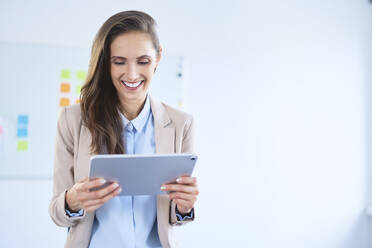 Smiling businesswoman using tablet in office - BSZF01481