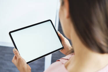 Close up of woman holding tablet in office - BSZF01514