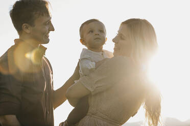 Happy family with little son in sunlight - LHPF01095