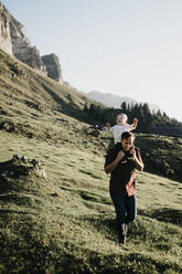 Glücklicher Vater trägt seinen kleinen Sohn auf den Schultern auf einer Wanderung, Schwaegalp, Nesslau, Schweiz - LHPF01098
