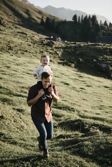 Glücklicher Vater trägt seinen kleinen Sohn auf den Schultern auf einer Wanderung, Schwaegalp, Nesslau, Schweiz - LHPF01099