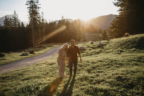 Glückliches junges Paar auf einer Wanderung bei Sonnenuntergang, Schwaegalp, Nesslau, Schweiz, lizenzfreies Stockfoto