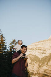 Glücklicher Vater trägt seinen kleinen Sohn auf den Schultern auf einer Wanderung, Schwaegalp, Nesslau, Schweiz - LHPF01128