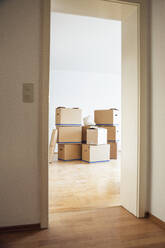 Cardboard boxes in an empty room in a new home - MAMF00792