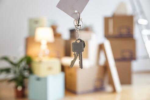 Hausschlüssel vor Kartons in einem leeren Raum in einer neuen Wohnung - MAMF00859