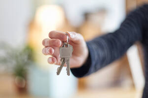 Close-up of man holding house key in new home - MAMF00862