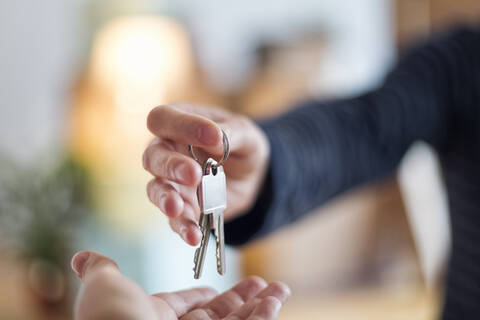 Nahaufnahme der Übergabe des Hausschlüssels in der neuen Wohnung, lizenzfreies Stockfoto