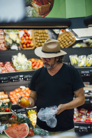 Älterer Mann kauft Lebensmittel in einem Supermarkt, lizenzfreies Stockfoto
