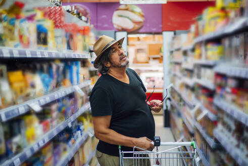 Älterer Mann beim Einkaufen in einem Supermarkt - CJMF00118