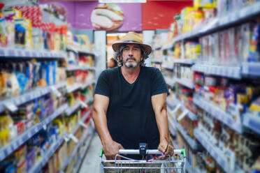 Porträt eines älteren Mannes beim Einkaufen in einem Supermarkt - CJMF00119