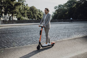 Geschäftsmann mit E-Scooter in der Stadt - JLOF00368