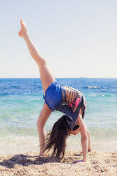 Girl doing gymnastics on the beach - XCF00281