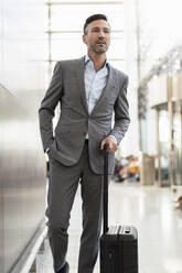 Portrait of confident businessman with baggage - DIGF08438