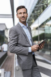 Portrait of confident businessman with tablet - DIGF08446