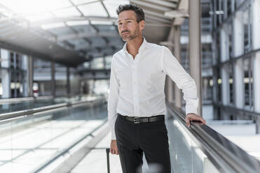 Businessman on moving walkway at the airport - DIGF08454