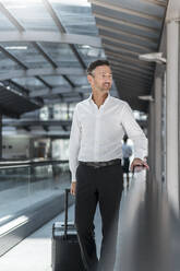 Businessman on moving walkway at the airport - DIGF08455