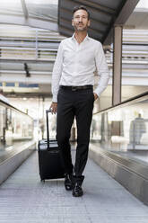 Businessman on moving walkway at the airport - DIGF08456