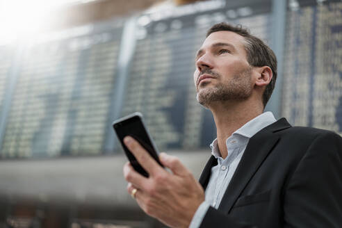 Porträt eines Geschäftsmannes mit Mobiltelefon bei der Ankunft Abflug Bord auf dem Flughafen - DIGF08476