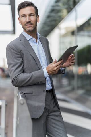 Porträt eines selbstbewussten Geschäftsmannes, der ein Tablet hält, lizenzfreies Stockfoto