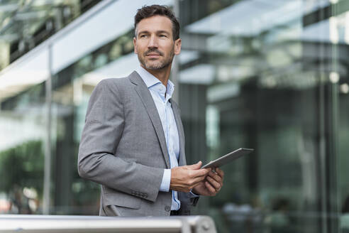 Portrait of confident businessman holding tablet - DIGF08487