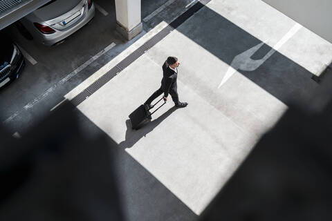 Draufsicht auf einen Geschäftsmann mit Gepäck, der unterwegs ist, lizenzfreies Stockfoto