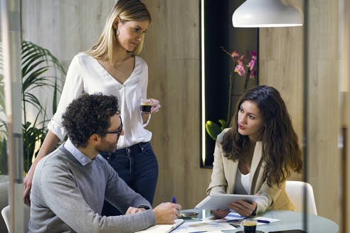Drei Geschäftsleute bei einem Treffen in einem modernen Büro - JSRF00684