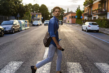 Man crossing street in the city - GIOF07168