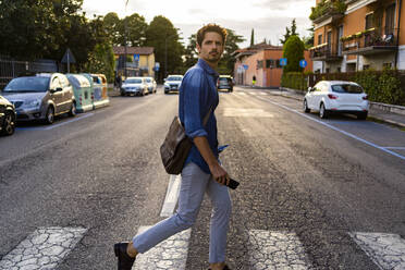 Mann beim Überqueren einer Straße in der Stadt - GIOF07168