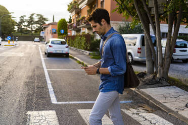 Man crossing street in the city - GIOF07169