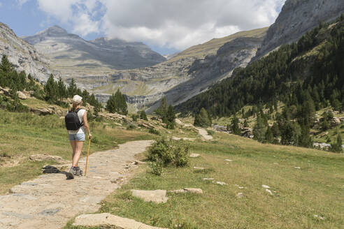 Rückansicht einer Frau auf einem Wanderweg in den Bergen, Nationalpark Ordesa, Aragonien, Spanien - AHSF00855