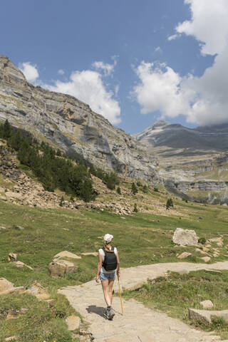Rückansicht einer Frau auf einem Wanderweg in den Bergen, Nationalpark Ordesa, Aragonien, Spanien, lizenzfreies Stockfoto