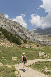 Rückansicht einer Frau auf einem Wanderweg in den Bergen, Nationalpark Ordesa, Aragonien, Spanien - AHSF00857